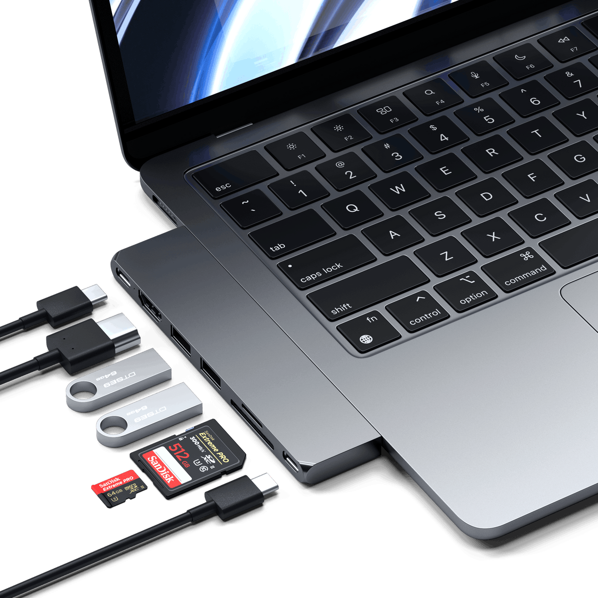 Pro Hub Slim in Space Gray plugged into an open MacBook with cables, flash drives and SD cards
