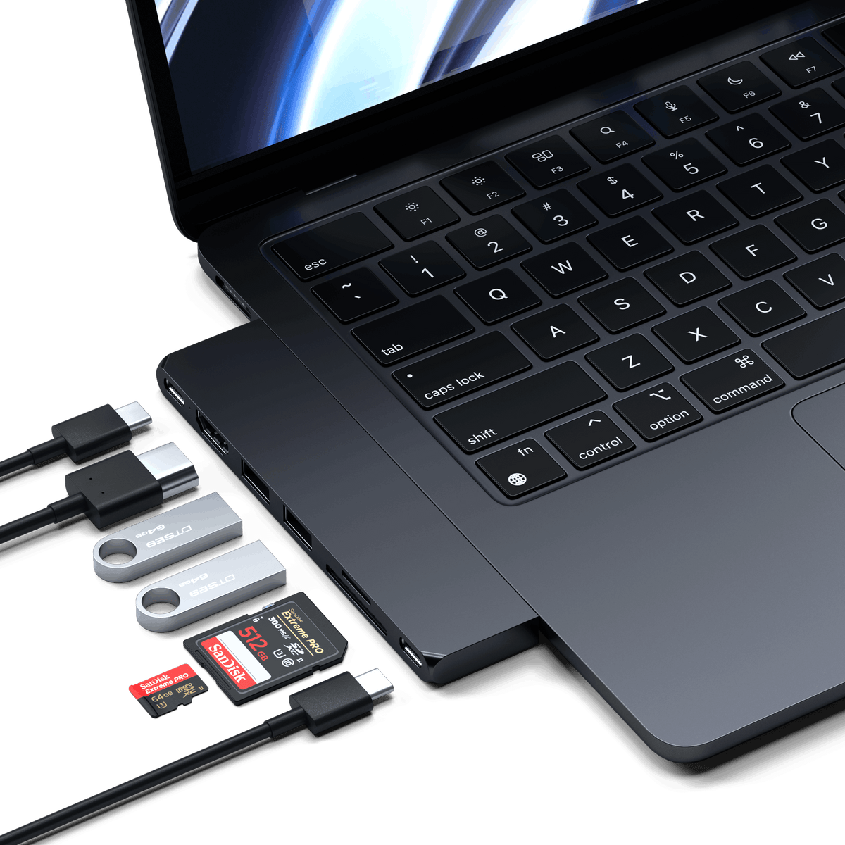 Pro Hub Slim in Midnight plugged into an open MacBook with cables, flash drives and SD cards