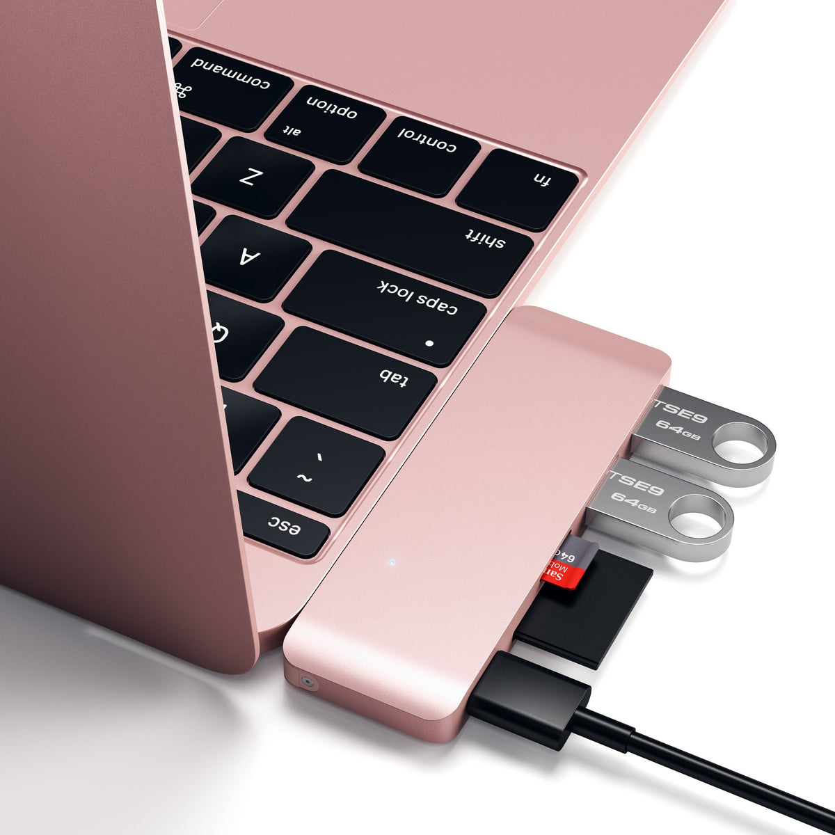 Type-C Pass-Through USB Hub in Rose Gold plugged into a MacBook with flash drives and an SD card, close up