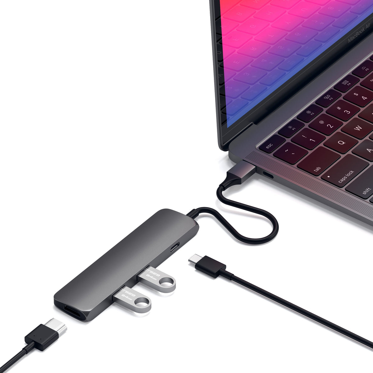Type-C Slim Multi-Port Adapter 4K in Space Gray plugged into a MacBook with cables and flash drives