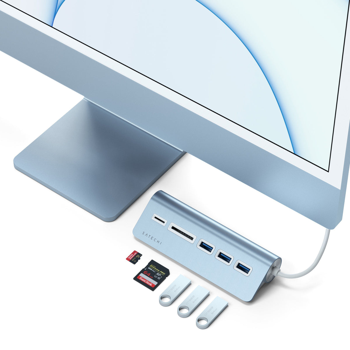 USB-C Combo Hub for Desktop in Blue on the stand of a blue 24-inch iMac with SD cards and flash drives