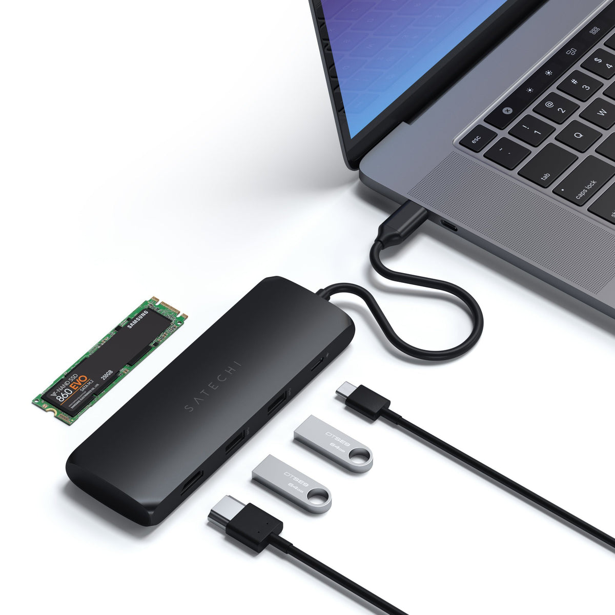 USB-C Hybrid Multiport Adapter in Black connected to a laptop with an M.2 SSD, HDMI cable and flash drives