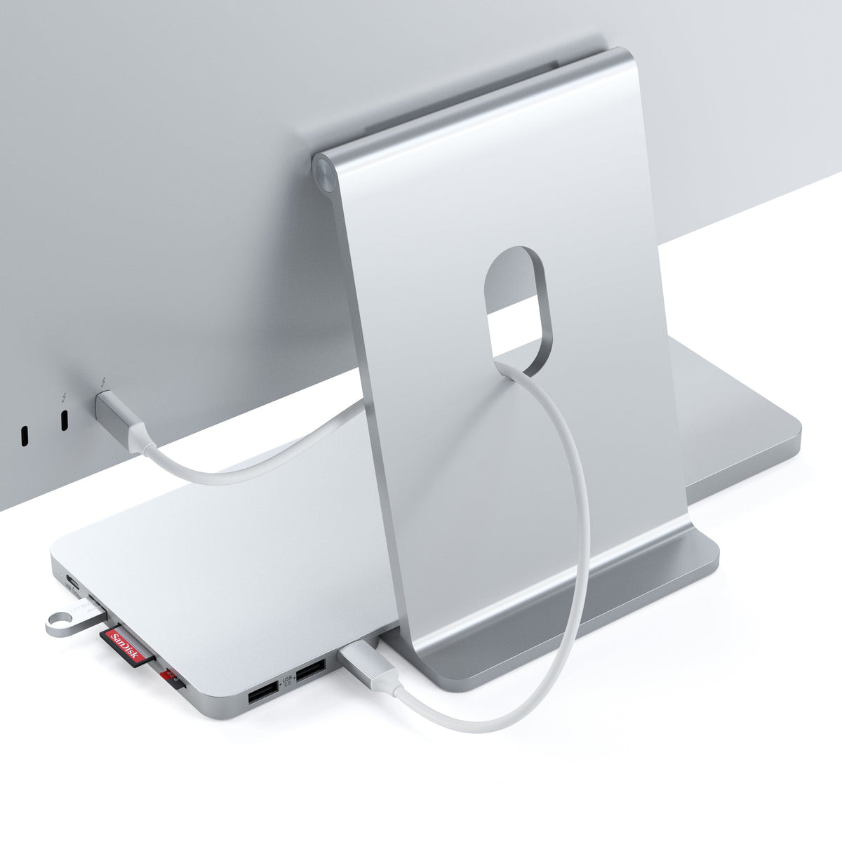 USB-C Slim Dock for 24" iMac in Silver, back view with its cable connected to the iMac and an SD card inserted
