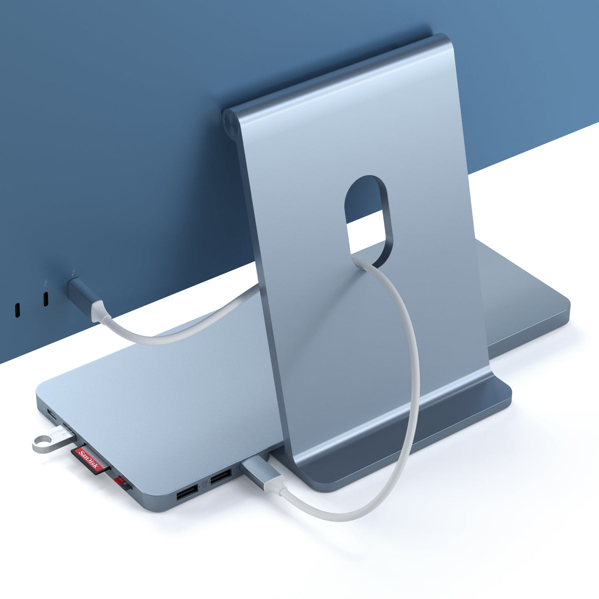 USB-C Slim Dock for 24" iMac in Blue, back view with its cable connected to the iMac and an SD card inserted